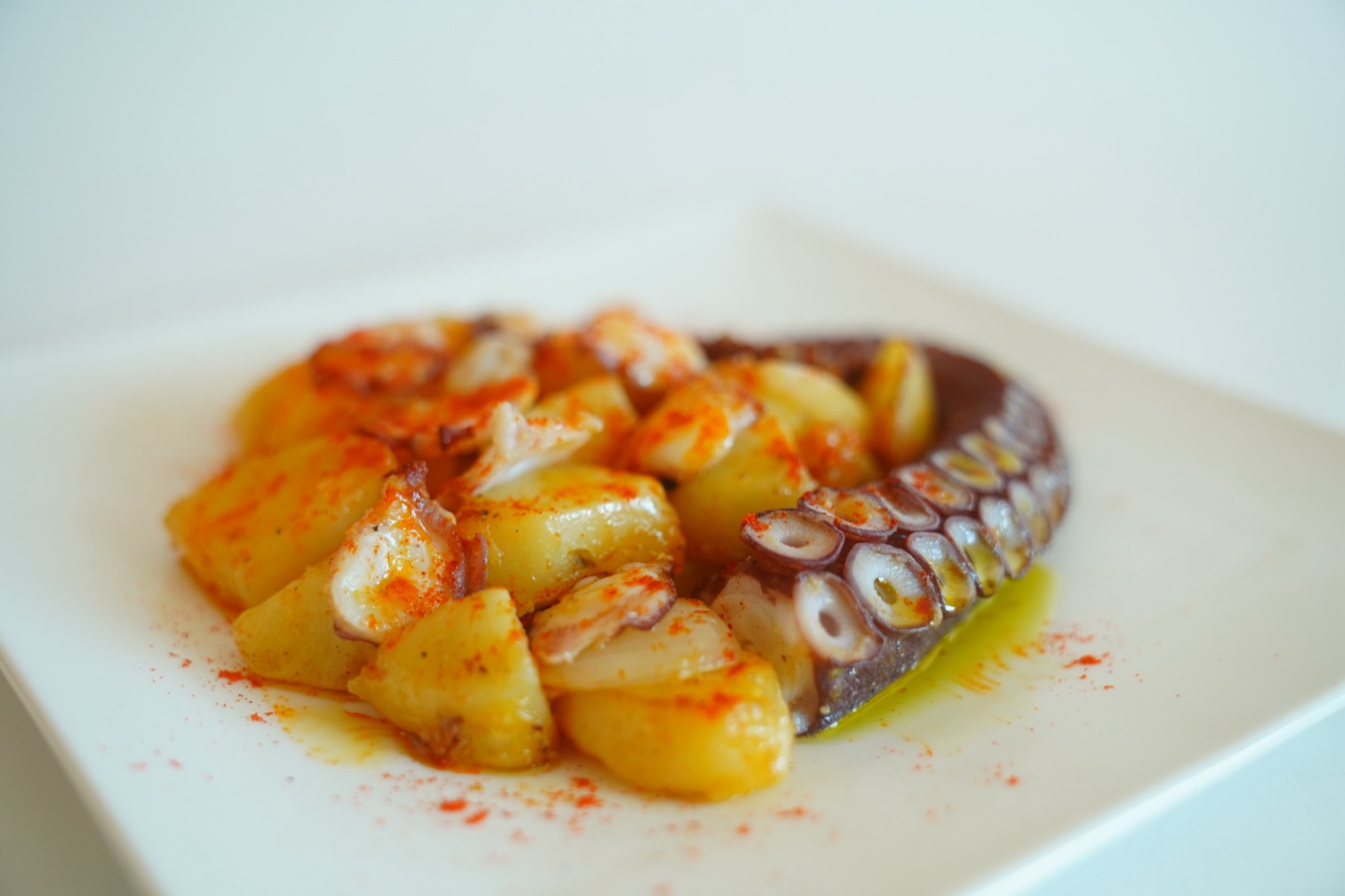 Octopus and potatoes dressed with olive oil and paprika