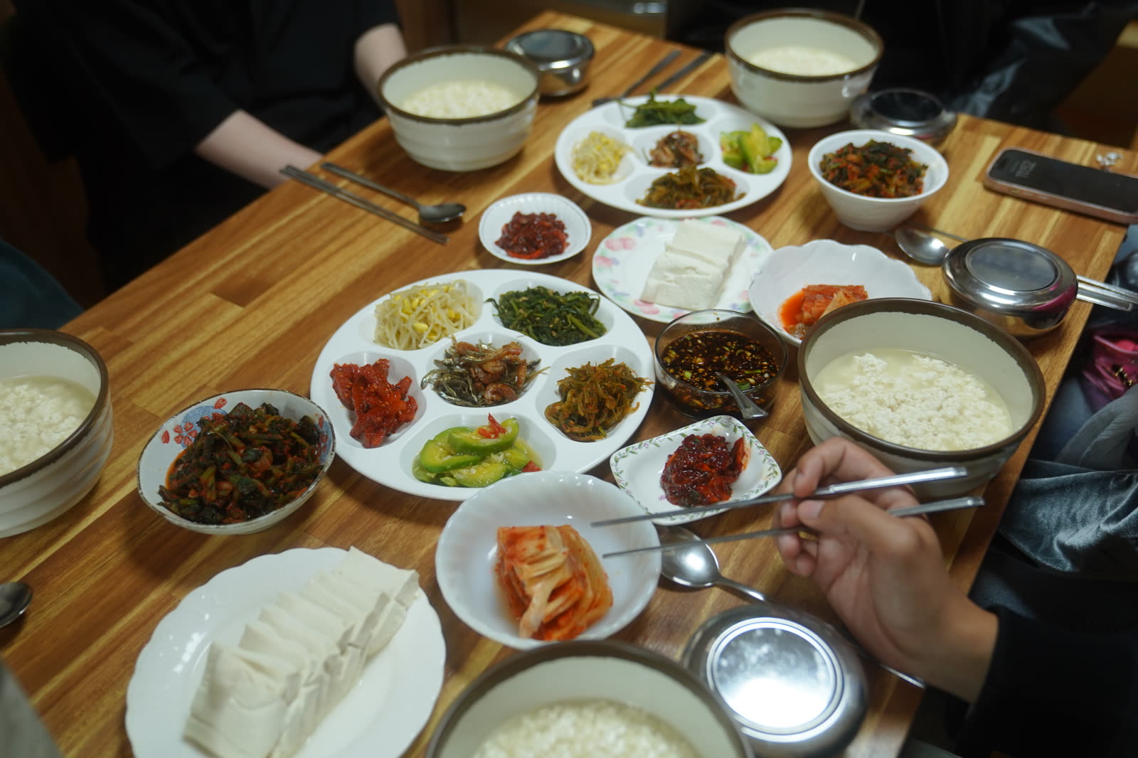 A shared table of dubu, rice and side dishes