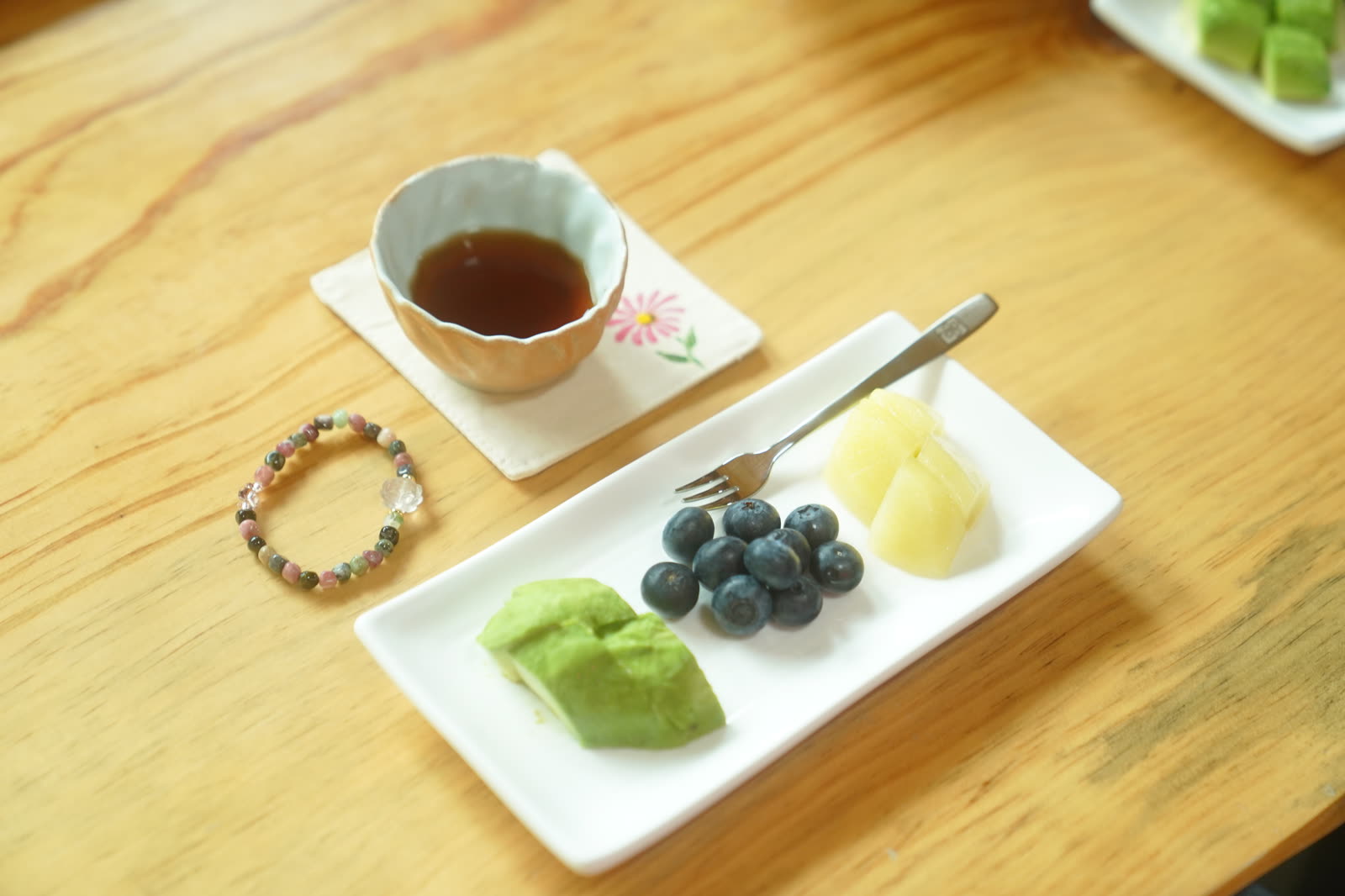 Tea, fruit and rice cakes laid out on a wooden table