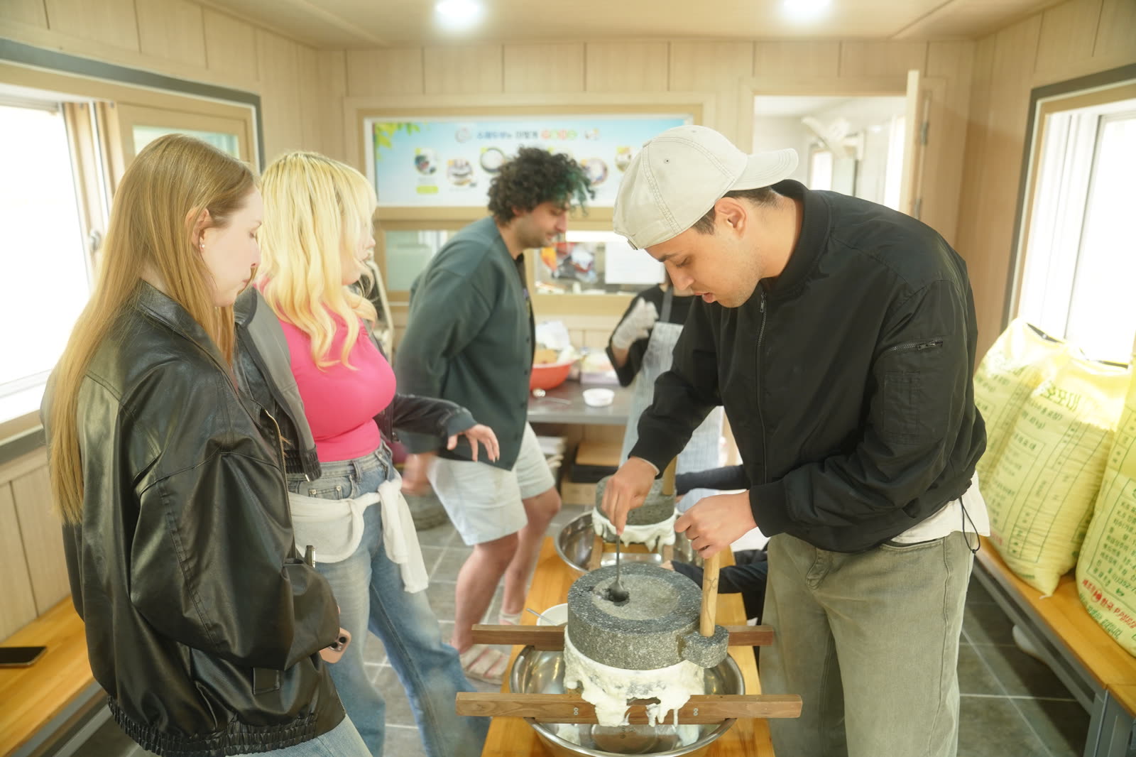 Guests turning a stone mill to grind soybeans